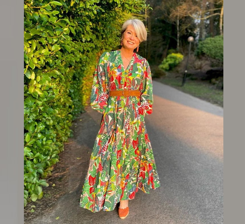 Older woman wearing a maxi dress with a statement necklace and sandals